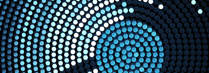 A digital abstract pattern displays concentric circles formed by illuminated blue and white dots on a dark background.